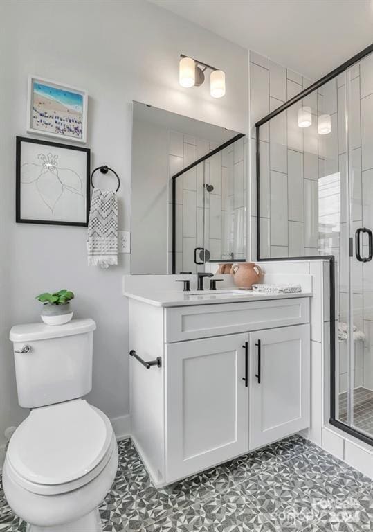 full bathroom featuring a shower stall, vanity, and toilet