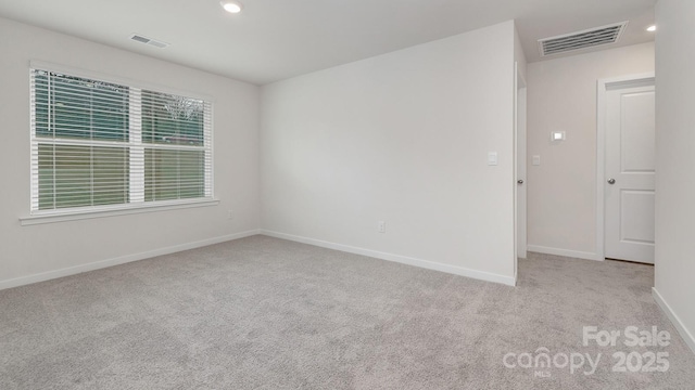 empty room featuring baseboards, visible vents, carpet flooring, and recessed lighting