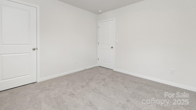 carpeted spare room with baseboards