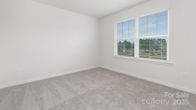 carpeted empty room with baseboards