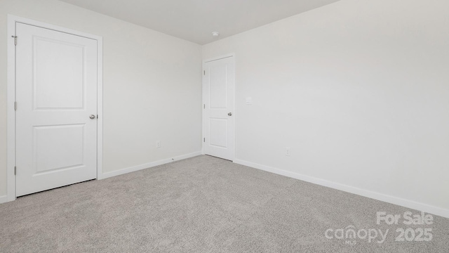 carpeted spare room with baseboards