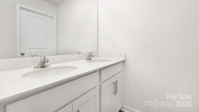 bathroom with a sink, baseboards, and double vanity