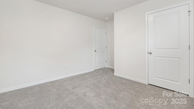 unfurnished bedroom featuring light colored carpet and baseboards