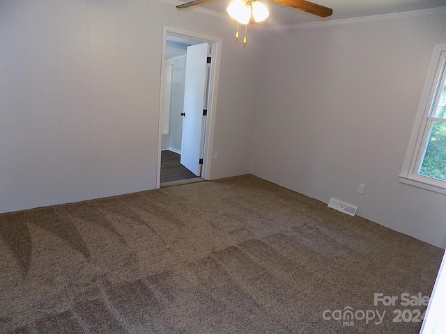 carpeted empty room featuring ceiling fan and ornamental molding