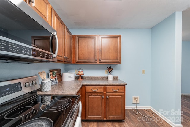 kitchen featuring appliances with stainless steel finishes and dark hardwood / wood-style floors