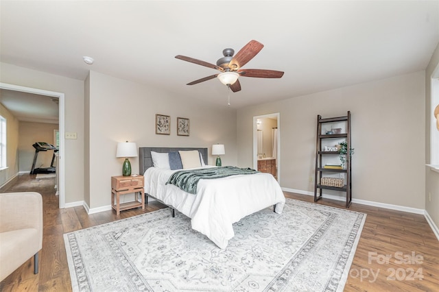 bedroom with connected bathroom, ceiling fan, and hardwood / wood-style flooring