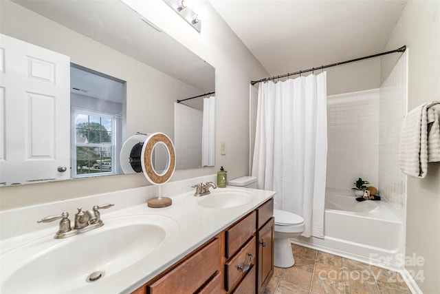 full bathroom with vanity, shower / bath combo with shower curtain, and toilet