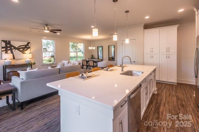 kitchen with stainless steel dishwasher, white cabinetry, sink, and an island with sink