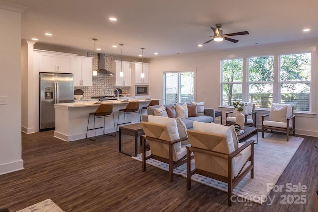 living room featuring ceiling fan, dark hardwood / wood-style flooring, and plenty of natural light