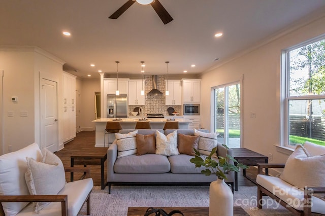 living room featuring a wealth of natural light, crown molding, ceiling fan, and hardwood / wood-style flooring