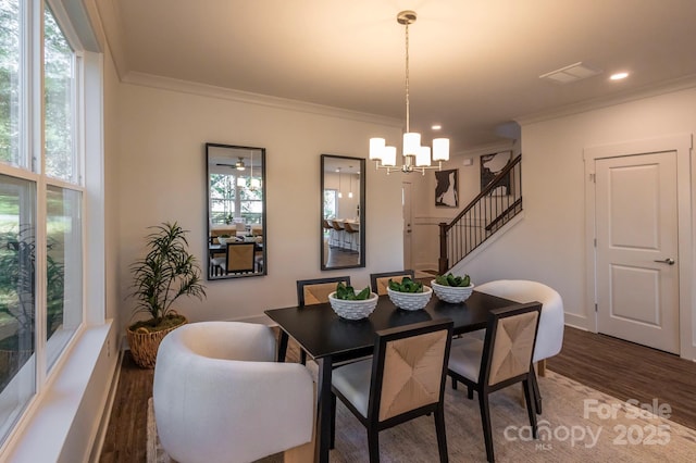 dining space featuring dark wood-type flooring, a notable chandelier, and ornamental molding