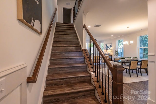 stairway featuring a chandelier and hardwood / wood-style floors