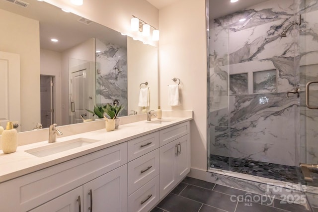 bathroom featuring tile patterned flooring, vanity, and a shower with shower door