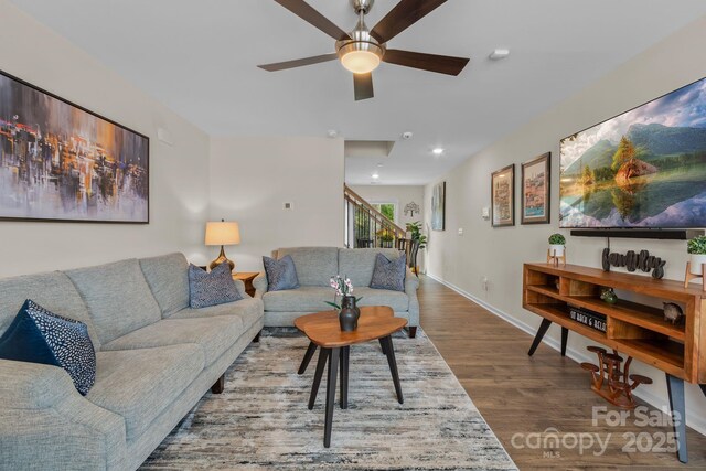 living room featuring ceiling fan and hardwood / wood-style floors