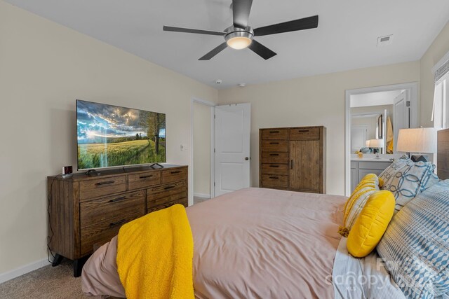 bedroom with carpet flooring, ensuite bathroom, and ceiling fan