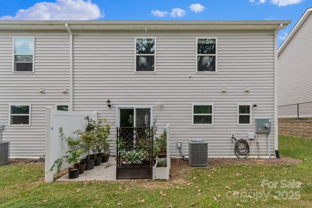 back of property featuring a lawn and central AC unit