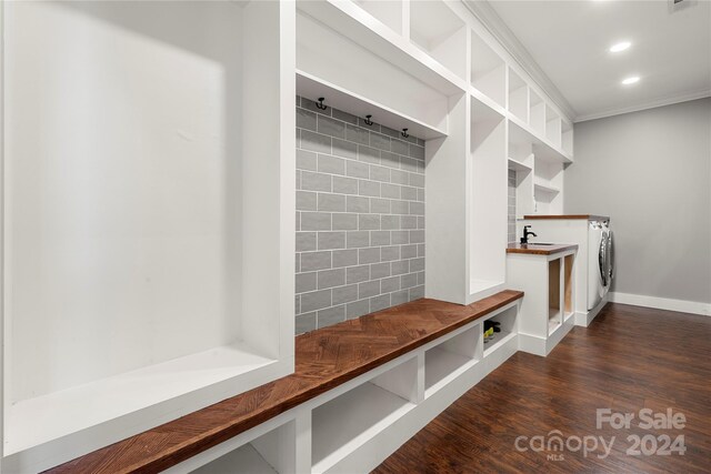 mudroom featuring dark wood-type flooring, crown molding, and washer / clothes dryer