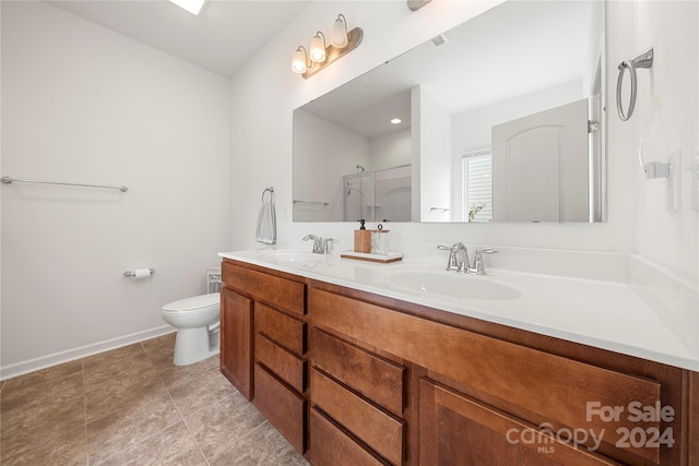 bathroom with vanity, toilet, and a shower with door