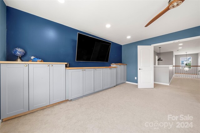 unfurnished living room featuring light colored carpet and ceiling fan