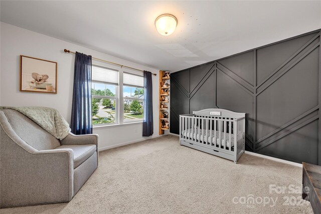 bedroom with a crib and light colored carpet