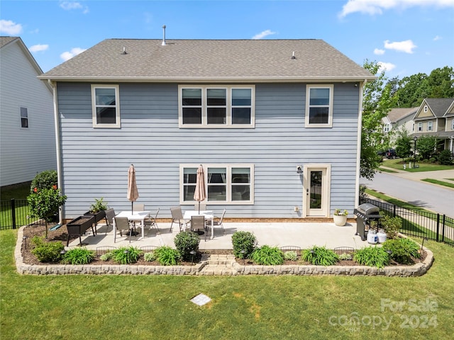 rear view of property featuring a lawn and a patio area