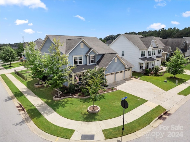 view of front of property with a garage, concrete driveway, a shingled roof, and a front lawn