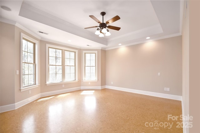 empty room featuring a raised ceiling and ornamental molding