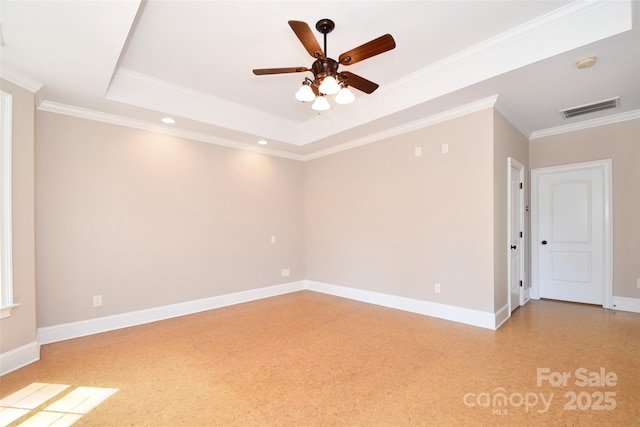 empty room featuring a raised ceiling, ceiling fan, and crown molding