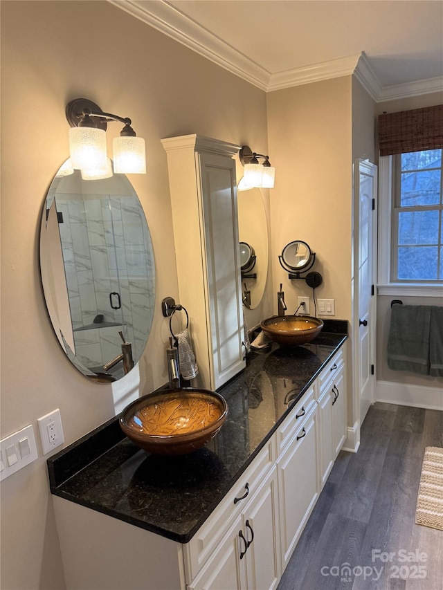 bathroom featuring hardwood / wood-style floors, vanity, a shower with door, and crown molding