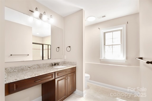 bathroom featuring tile patterned flooring, vanity, toilet, and walk in shower