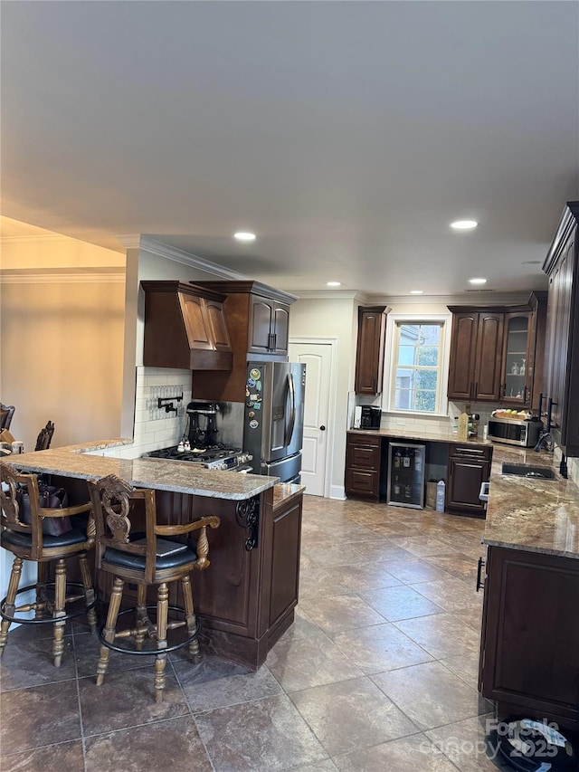 kitchen featuring a kitchen breakfast bar, kitchen peninsula, stainless steel fridge with ice dispenser, and beverage cooler