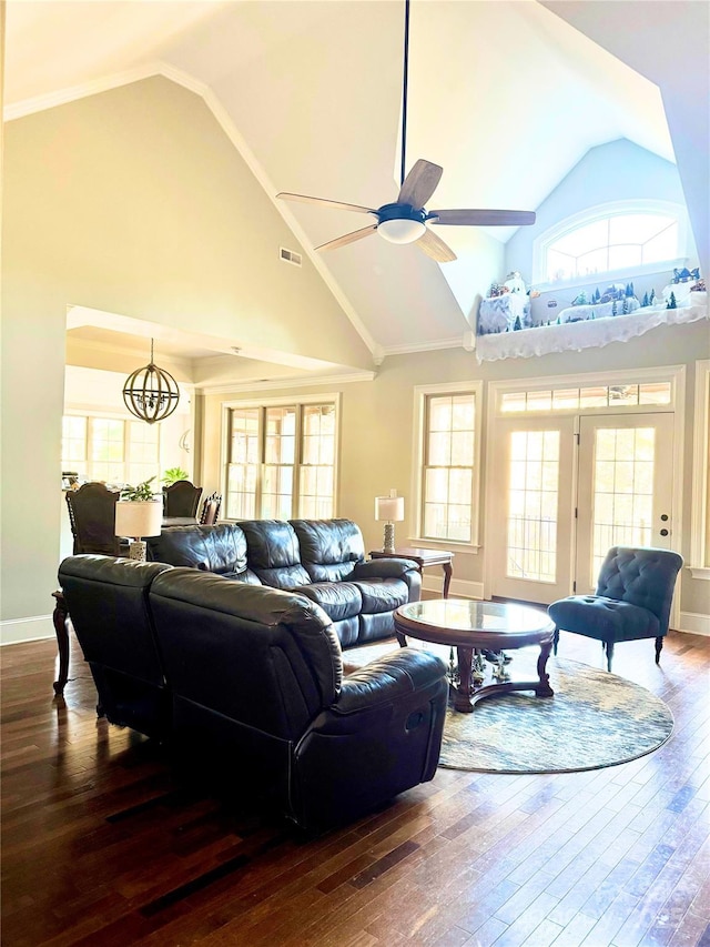 living room with vaulted ceiling, a healthy amount of sunlight, ceiling fan with notable chandelier, and hardwood / wood-style flooring