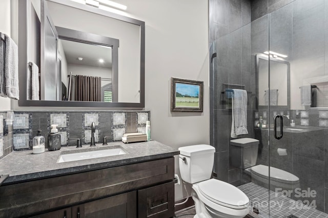 bathroom with vanity, toilet, and a shower with shower door