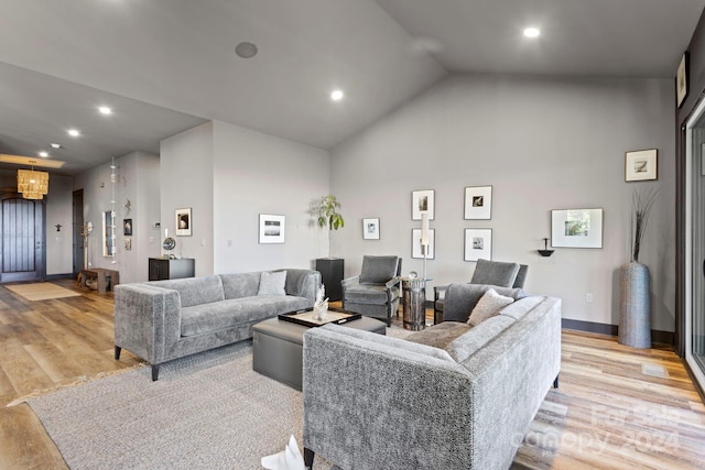 living room featuring high vaulted ceiling and light wood-type flooring