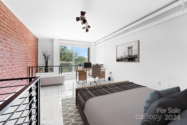 bedroom featuring brick wall and concrete floors