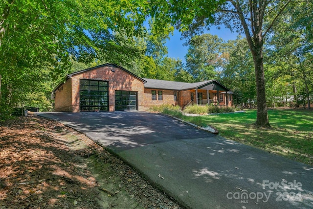 single story home featuring a garage and a front lawn