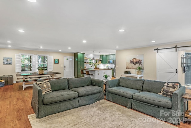 living room featuring a barn door and light hardwood / wood-style floors