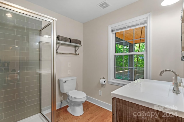 bathroom with an enclosed shower, toilet, hardwood / wood-style flooring, and vanity