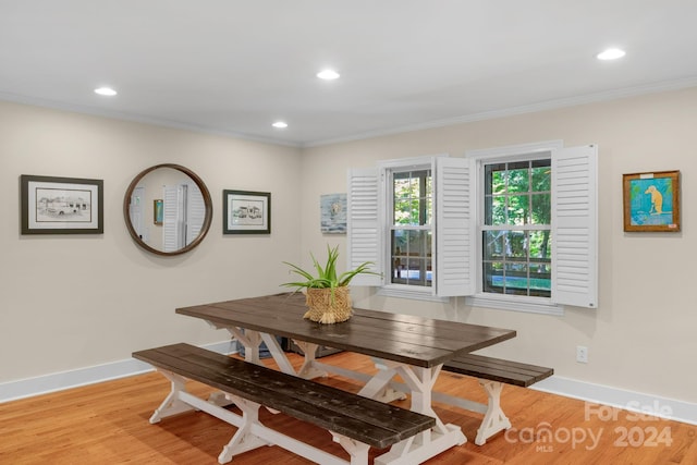 dining area featuring light wood-type flooring and crown molding