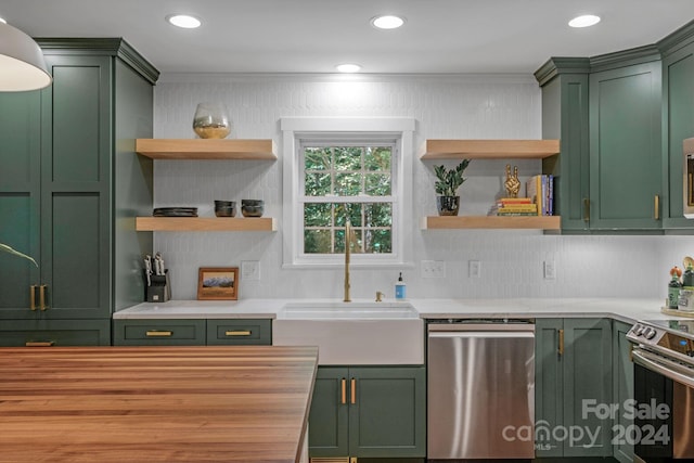 kitchen featuring stainless steel appliances, green cabinetry, and backsplash