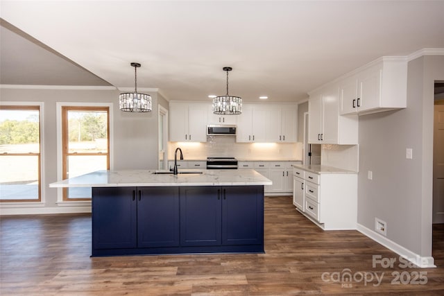 kitchen featuring appliances with stainless steel finishes, a kitchen island with sink, sink, white cabinets, and light stone counters