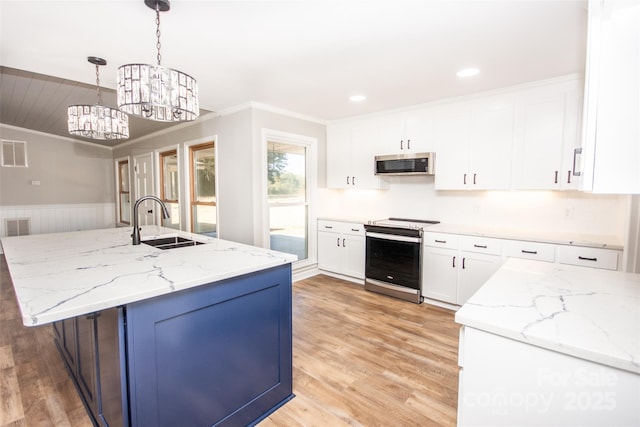 kitchen featuring white cabinets, appliances with stainless steel finishes, and pendant lighting