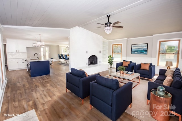 living room featuring sink, wood ceiling, ceiling fan with notable chandelier, ornamental molding, and light hardwood / wood-style floors