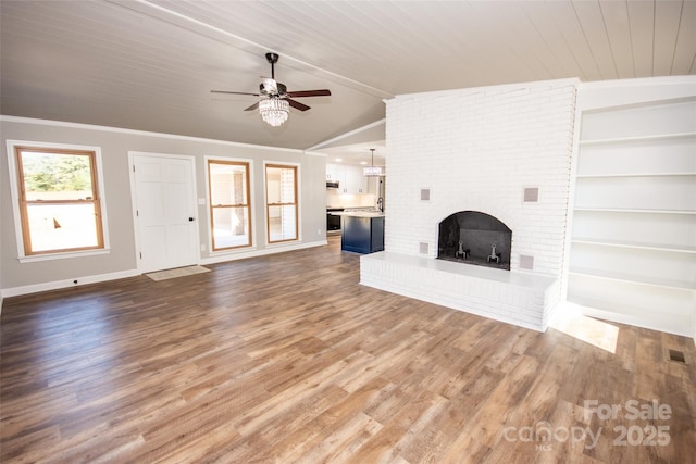 unfurnished living room featuring vaulted ceiling, a brick fireplace, ceiling fan, and dark hardwood / wood-style floors