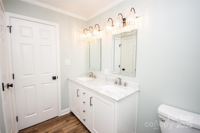 bathroom featuring vanity, hardwood / wood-style flooring, ornamental molding, and toilet