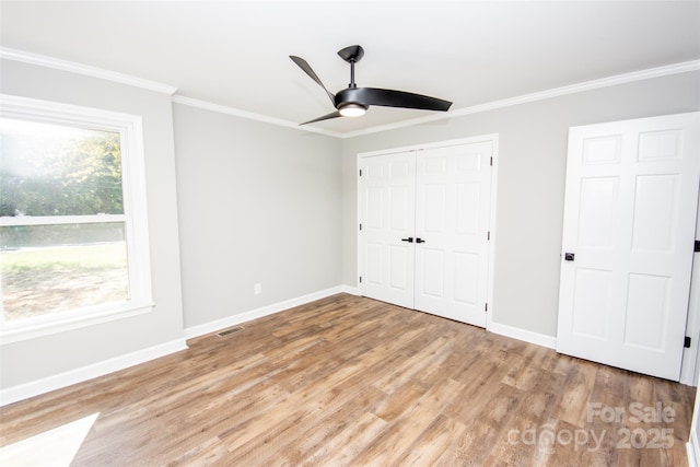 unfurnished bedroom featuring ceiling fan, crown molding, and light hardwood / wood-style floors