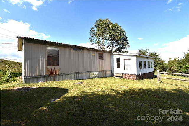 back of property with a yard and fence
