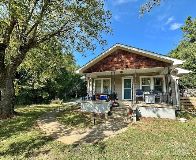 rear view of house with a yard and a porch