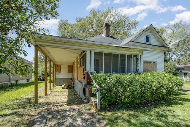 view of front facade with a sunroom and a front lawn