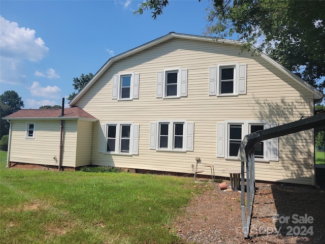 back of house featuring a yard and a gambrel roof